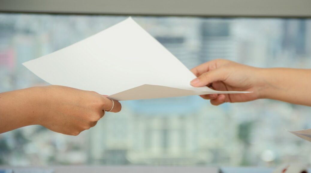 person handing over paper